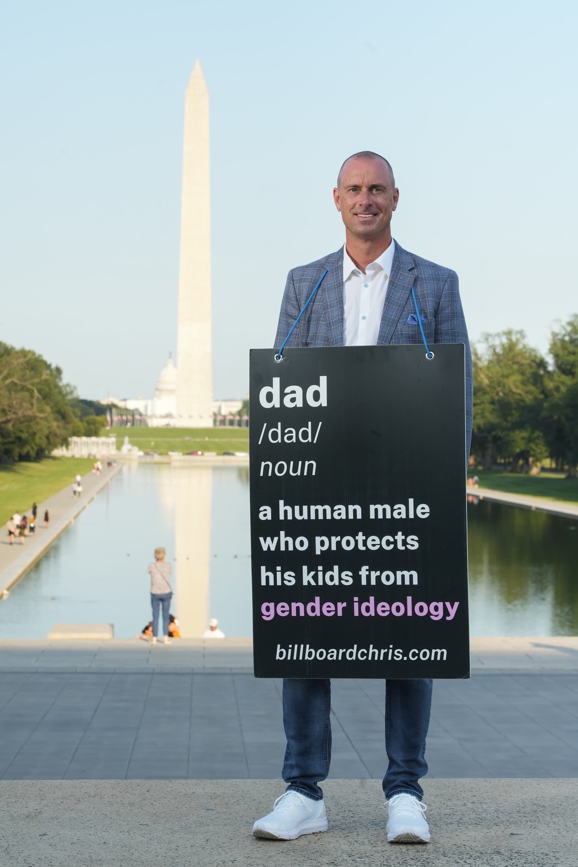 Chris hält ein Schild: Vater — ein männlicher Mensch, der seine Kinder vor der Gender-Ideologie schützt