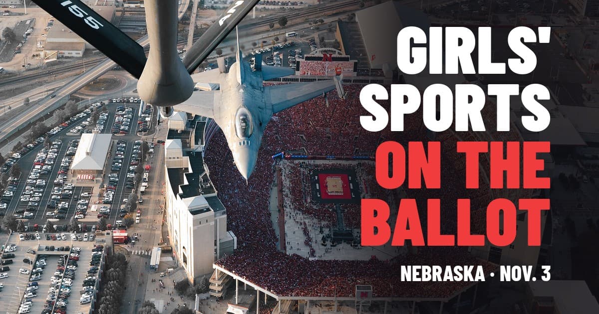 منظر جوّي لـ Memorial Stadium في Lincoln مكتظ في Nebraska Volleyball Day، وطائرتا KC-135 وF-16 تحلّقان فوقه